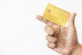 Close-up hand of Asian man holding yellow gold credit card in his hand. isolated on white background. Concept of finance, trading Royalty Free Stock Photo