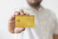 Close-up hand of Asian man holding yellow gold credit card in his hand. isolated on white background. Concept of finance, trading Royalty Free Stock Photo