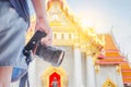 Close up hand asian man traveling backpacker holding camera at Wat Benchamabophit Dusitvanaram in Bangkok, Thailand Royalty Free Stock Photo