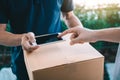 Close up of hand asian man using smartphone pressing screen to sign for delivery from the courier at home