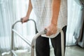 Close up hand of Asian Senior elderly disabled man patient walk slowly with walker at nursing home. Older handicapped male have we