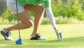 Close up hand asian sporty woman put golf ball on tee with club in golf course evening Royalty Free Stock Photo