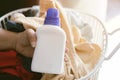 Close up hand of Asian woman holding bottle of detergent and clean towels on table indoors, space for text Royalty Free Stock Photo