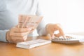 Close-up hand  asian woman using calculator counting and count money in home Royalty Free Stock Photo