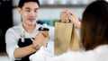 Close up hand. Asian young man or bartender serving paper bag and paper coffee glass customer at coffee shop. making coffee in Royalty Free Stock Photo