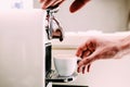 Close up of hand of barista brewing coffee using a coffee machine. Man`s hand with a cup of fresh coffee with foam Royalty Free Stock Photo