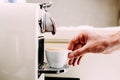 Close up of hand of a barista making coffee using a coffee machine. Man`s hand with a cup of fresh coffee with foam Royalty Free Stock Photo