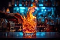 Close up of hand of bartender making cocktail at bar counter in night club, A glass of fiery cocktail on the bar counter against