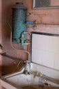 Close up of hand basin and oxidised water heater in derelict house built in 1930s deco style, Rayners Lane, Harrow UK