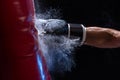 Close-up hand of boxer at the moment of impact on punching bag over black background