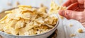 Close up of hand breaking peanut brittle, crispy texture with peanuts, bright white background