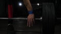 Close-up of the hand, the brush that grips the bar of the heavy barbell