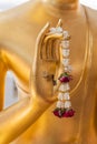 Close up Hand of The Buddha statue gold color hold flower garland in temple Royalty Free Stock Photo