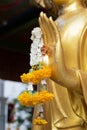 Close up Hand of The Buddha statue gold color hold flower garland in temple Royalty Free Stock Photo