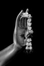 Close up Hand of The Buddha statue hold flower garland in temple at thailand black and white color isolated on black background Royalty Free Stock Photo