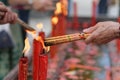 Hand burning incense sticks on red candle fire Royalty Free Stock Photo