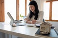 Close up hand of Business asian woman using calculating interest, taxes and profits to invest in real estate and home Royalty Free Stock Photo