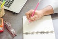 Close up of the hand of a business planning or taking notes and laptop on your desk at home. Royalty Free Stock Photo