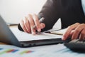 close-up hand of businessman analyzing investment chart on paperwork with laptop in office. concept finance and accounting Royalty Free Stock Photo