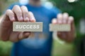 Close up Hand of businessman choosing wood blog with word SUCCESS and blurred word FAILURE, financial concept for business Royalty Free Stock Photo