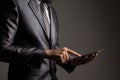 Close up. Hand of businessman in grey suit holding and touching application,Checking the growth rate of the stock market. Royalty Free Stock Photo