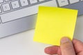 Human hand holding yellow sticky note Royalty Free Stock Photo