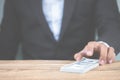 Close up hand of businessman holding money dollar bills on wooden table. Using as concept of corruption , Business corruption, Royalty Free Stock Photo