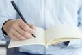 Close up hand of businessman holding pen and notebook, Writing something idea on note or check list Royalty Free Stock Photo