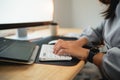 Close up of hand businesswoman typing on keyboard and working laptop on wooden table at home. Entrepreneur woman working for her