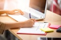 Close up Hand of businesswoman writing on paper with laptop computer in cafe. Concept business plan Royalty Free Stock Photo