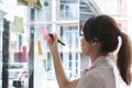 Close up hand businesswoman writing sticky notes on glass wall in office Royalty Free Stock Photo