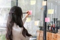 Close up hand businesswoman writing sticky notes on glass wall in office Royalty Free Stock Photo