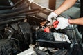 Close up hand of Car repairman with multimeter device for check up car battery life, battery inspection Royalty Free Stock Photo