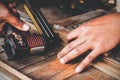 Close-up Hand of carpenter use gun fired a nail wood working machine tool, furniture boxes at workshop