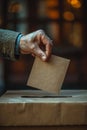 Close-up of a hand casting a vote in a ballot box