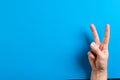 Close up of hand of caucasian woman showing peace sign with copy space on blue background Royalty Free Stock Photo