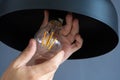 Close-up. A hand changes a light bulb in a stylish loft lamp. Spiral filament lamp. Modern interior decor