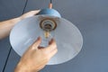 Close-up. A hand changes a light bulb in a stylish loft lamp. Spiral filament lamp. Modern interior decor