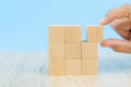 Close-up hand choose a cube shape wooden block toy stacked without graphics for Business design concept and activity for child fou Royalty Free Stock Photo