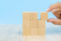 Close-up hand choose a cube shape wooden block toy stacked without graphics Royalty Free Stock Photo