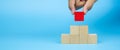 Close-up hand choose cube wooden block toy stack in pyramid without graphics Royalty Free Stock Photo