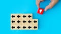 Close-up hand choose cube wooden toy block stacked with arrow icon pointing to opposite directions for way of business change Royalty Free Stock Photo