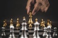 Close up hand choose gold chess to challenge with silve chess team on chess board