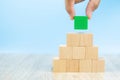 Close-up hand choose a green wooden block toy stacked in pyramid shape without graphics for Business design Royalty Free Stock Photo