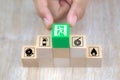 Close-up hand choose a wooden toy blocks stacked in pyramid with fire exit icon Royalty Free Stock Photo