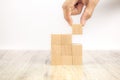 Close-up hand chooseing cube wooden block toy stacked without graphics