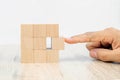 Close-up hand chooseing cube wooden block toy stacked without graphics