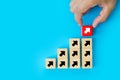 Close-up hand chooses cube wooden toy block stack with arrow icon pointing to opposite directions for way of business change or