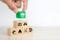 Close-up hand chooses cube wooden toy blocks stacked with prevent protect icon