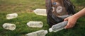 Close up hand collects plastic bottle in a park. A volunteer cleaning garbage.